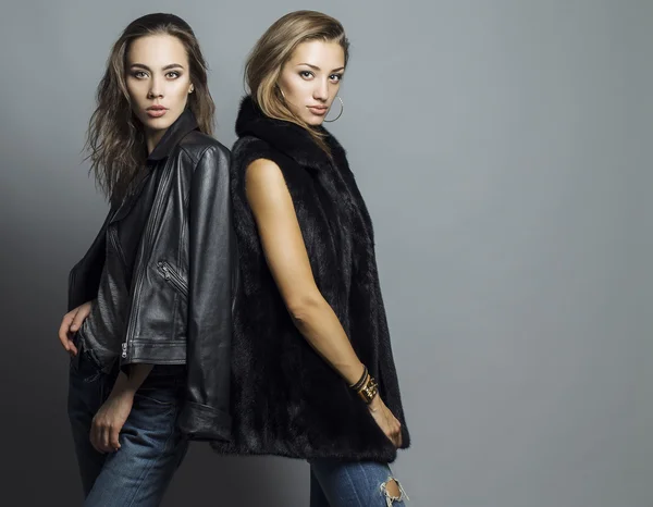 Foto de moda de duas meninas bonitas elegantes (morena e loira) em estúdio em fundo cinza, vestida com roupas casuais. Inspiração de compras — Fotografia de Stock