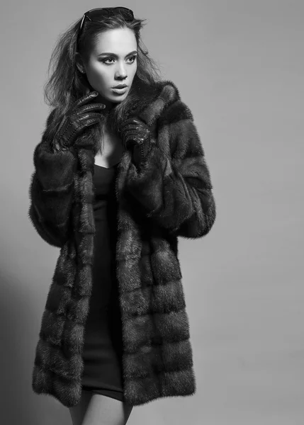 Sexy Beauty Girl with natural  Make up.  Fashion Brunette  Portrait of a girl dressed in fur coat,  black dress and sunglasses posing on a grey background. Retro style. Monochrome (black and white)  photo — 스톡 사진