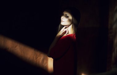 Moda stil günbatımında cadde boyunca yürüyen genç trendy kız portresi. Kırmızı bir elbise kavramı. kusursuz bir beden ve yapısı. Vintage tarzı fotoğraf özel beyaz dengesi, renk filtreleri ve görüntüye eklenen bazı iyi film gürültü ile