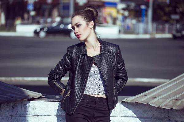 Concept de beauté féminine. Portrait de jeune fille à la mode en jean noir décontracté, veste noire, crop-top blanc, lunettes de soleil et petit sac posant dans la rue. Cheveux et peau parfaits. Style vogue. plan extérieur — Photo