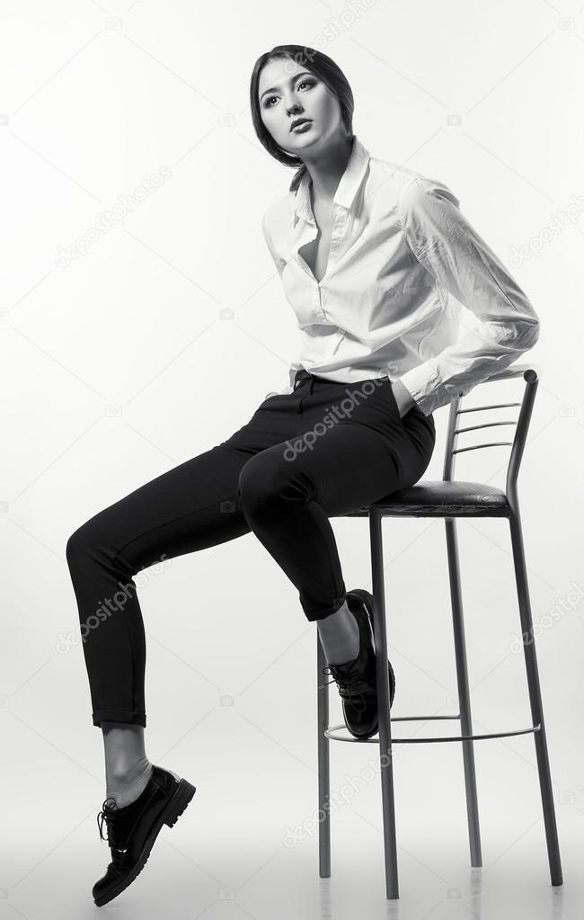 Female beauty concept. Portrait of fashionable young girl in classic clothes posing over white background. Perfect hair & skin. Vogue style. Studio shot