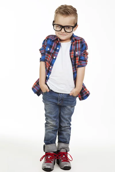 Śmieszne child.fashionable mały chłopiec w okularach, dżinsy, biały t-shirt i kratki shirt.stylish dziecko w buty sportowe. moda dzieci — Zdjęcie stockowe