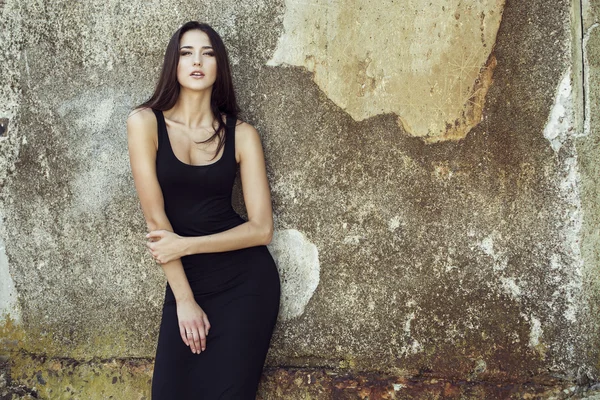 Fashion portrait of young beautiful brunette girl in sexy black dresss.  Outdoor shot.  Urban style — Stock Photo, Image