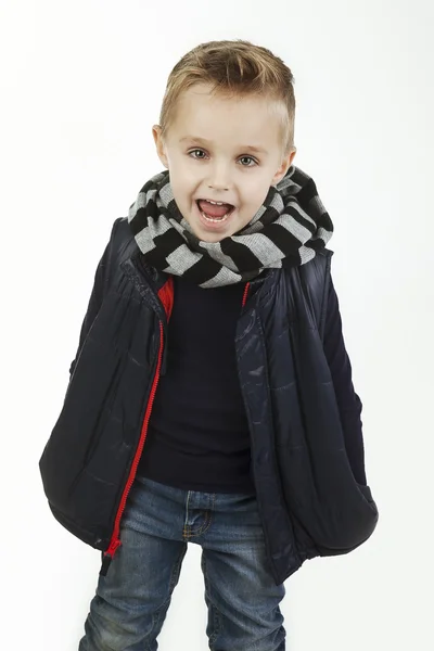 Criança engraçada. menino na moda em jeans, camisa preta, silencioso listrado de lã e colete acolchoado. Garoto sorridente elegante. moda crianças — Fotografia de Stock