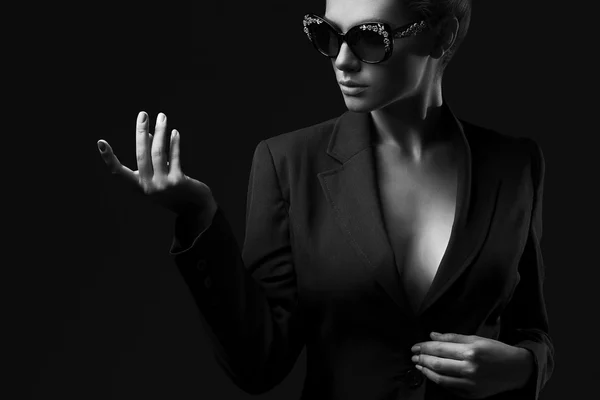 Portrait of a beautiful girl posing in studio in black jacket and fashion sunglasses. The concept of stylish and sexy women. perfect skin and body — 图库照片
