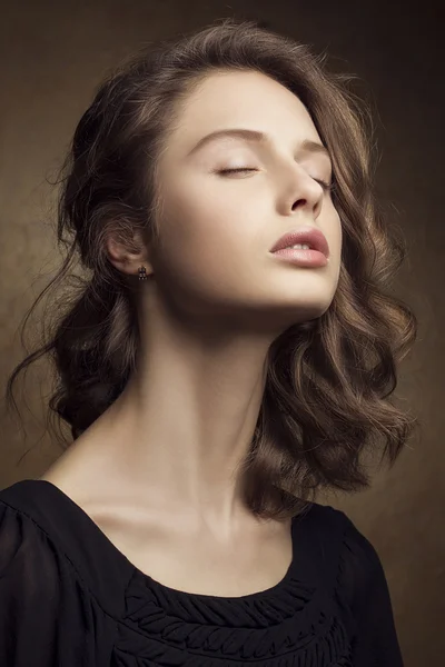 Emotive portrait of a beautiful fashion red-haired model with a natural makeup posing over golden background. Retro style hairdo. Studio shot — ストック写真