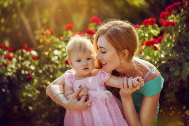 mutlu bir aile. Anne ve bebek bir çayır yaz aylarında açık havada parkta oturan