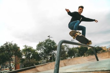 Arka planda telif alanı olan şehir dışındaki bir yerde yılan panosuyla tırabzan gıcırdatan bir çocuk.