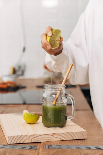 靠近点女人的手在绿色果汁里捏石灰可重复使用的竹杆 厨房柜台顶部 烹饪的概念 健康生活方式概念 — 图库照片