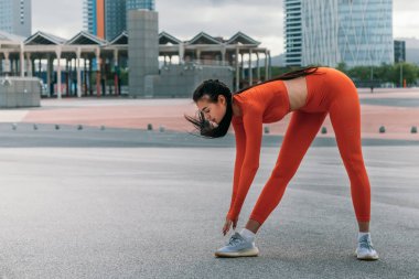 Genç bayan sporcu koşmadan önce bacak kaslarını esnetiyor. Beyaz kadın antrenmandan önce ısınıyor. Aktif yaşam tarzı konsepti. Spor konsepti.