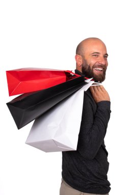 Omzunda alışveriş torbaları taşıyan gülümseyen beyaz bir adam. Beyaz arka planda izole edilmiş. Dikey görüntü. Kara Cuma konsepti. Alışveriş konsepti.