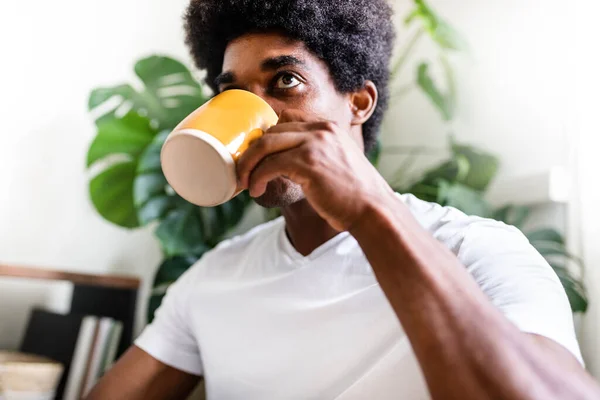 若いアフリカ系アメリカ人の男性は家で一人でモーニングコーヒーを飲む 家のコンセプトで — ストック写真