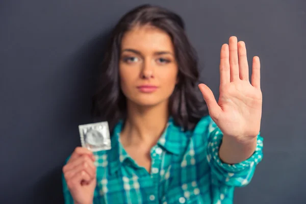 Attractive young woman with condom — Zdjęcie stockowe