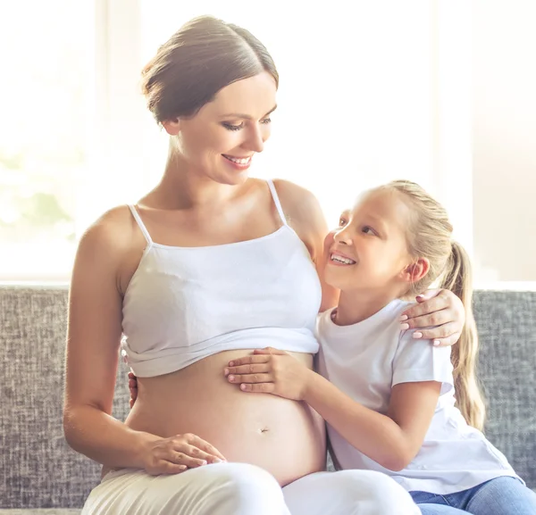 Беременная женщина с дочерью — стоковое фото