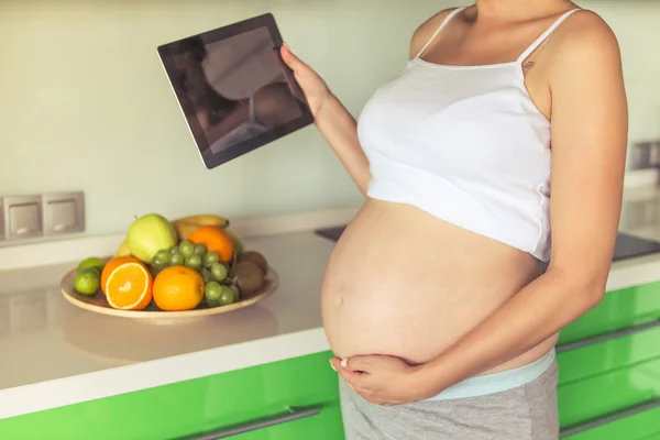 Těhotná žena v kuchyni — Stock fotografie