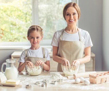 Anne ve kızı yemek pişiriyor.