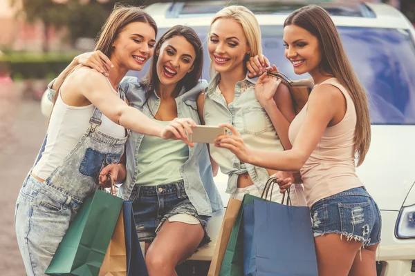 Девушки ходят по магазинам с машиной — стоковое фото