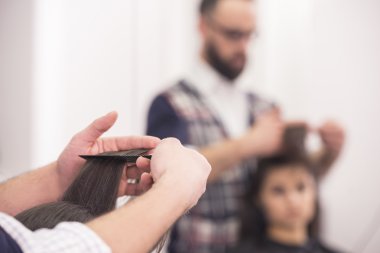 yakın çekim Kuaför salon bir istemci için bir saç kesimi yapma. arka plan bulanık.