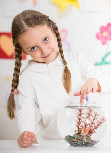 Kleines Mädchen spielt mit Goldfischen — Stockfoto