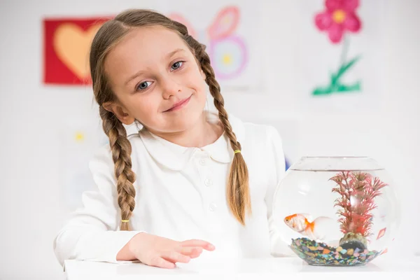 Little girl playing with gold fish — Stock Photo, Image