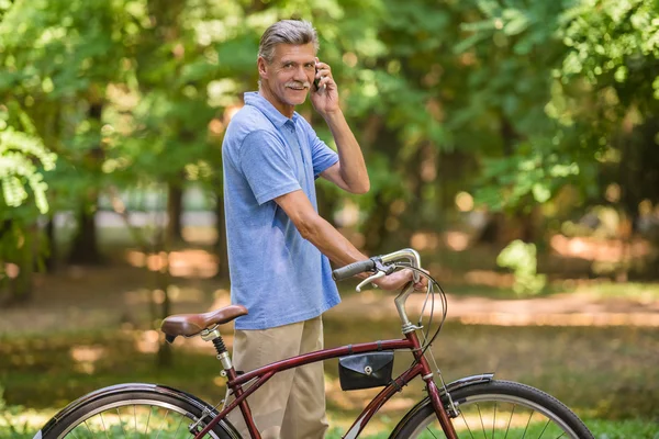 Senior Telefoniert Mit Fahrrad Park — Stockfoto