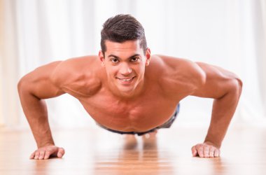 Yakışıklı kaslı adam gönderme yapıyor up ve kameraya bakıyor.