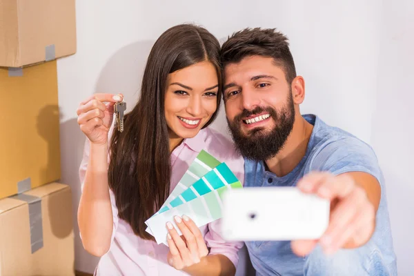 Young happy couple holding keys to new home, moving to a new home