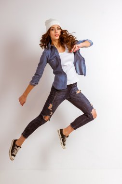 Uzun kıvırcık saçlı güzel bir genç kızın portresi, mavi arka plan üzerinde izole