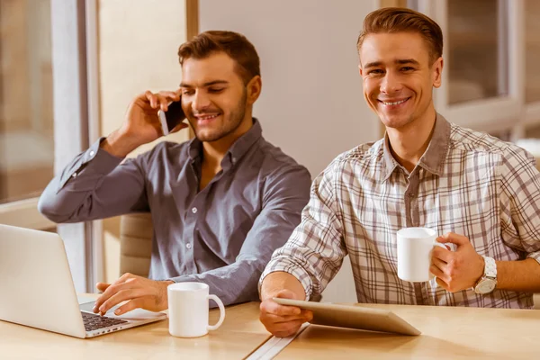 Jóvenes hombres de negocios guapos coworking —  Fotos de Stock