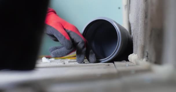 Installazione del tubo fognario posteriore inclinato in casa. Condurre fognature in casa. Idraulico mettendo la mano nel tubo fognario in appartamento. — Video Stock