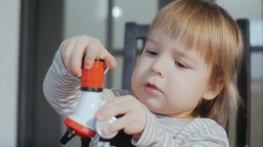 Oyuncak bebek mikroskobu kullanan tatlı çocuk. Çocuklar için eğitici oyuncaklar.
