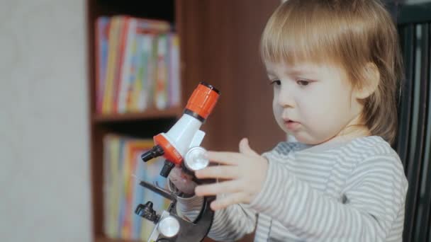 Educatief speelgoed voor kinderen. Little boy 2-3 jaar oud spelen met een speelgoed microscoop — Stockvideo