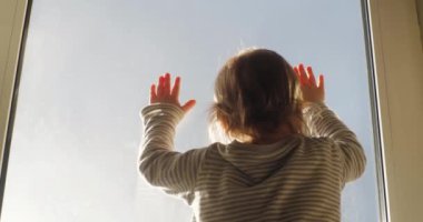 Pencereden dışarı bakan çocuk, dikiz aynası. Bebek pencereden dışarı bakıyor, elleri camın üzerinde, arkadan manzarası....