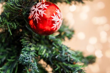 Ağaçtaki kırmızı Noel süsü. Arka plandaki ışıkları söndür