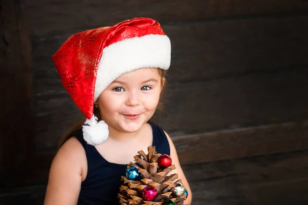 Retrato Criança Chapéu Papai Noel Fundo Madeira Menina Segurando Cone — Fotografia de Stock