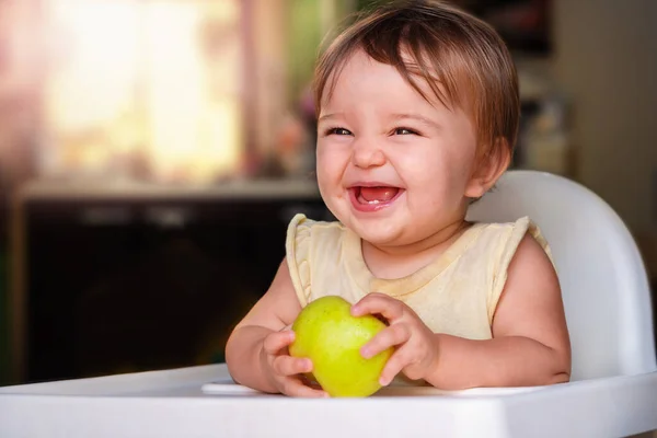 Bebek Gülümsüyor Elinde Yeşil Bir Elma Tutuyor Çocuk Beslenme Sandalyesinde — Stok fotoğraf