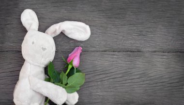 Güllü oyuncak. Tahta arka planda çiçekli oyuncak tavşan