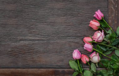 Ahşap arka planda çiçekler. Ahşap yüzeyde kopyalanmış pembe gül çerçevesi