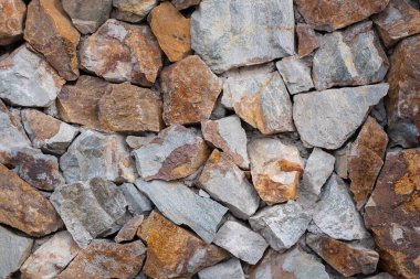 Taş duvar arka planı. Gri, turuncu taşların doku duvarı
