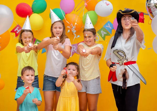 Children and pirate at the birthday party on a yellow background
