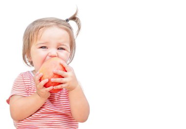 Çocuk beyaz arka planda izole edilmiş bir elmayı ısırır.