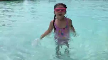 Çocuk tatilde havuzda yüzer.