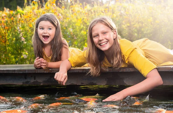 Дівчата Сестри Лежать Мосту Годують Рибу Парку Відкритому Повітрі — стокове фото