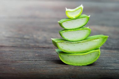Ahşap yüzeydeki yığında taze yeşil aloe parçaları.