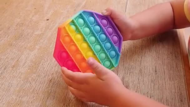 Criança Brincando Com Pop Brinquedo Silicone Mesa Madeira — Vídeo de Stock