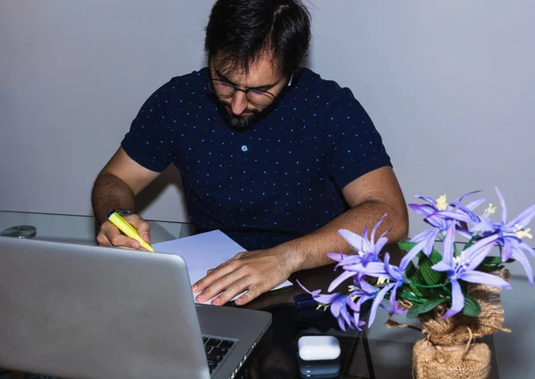Adam evde çalışıyor, müzik dinliyor ve bir toplantı hazırlıyor.