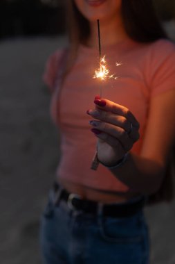 Bulanık arka planda maytap olan kadın.