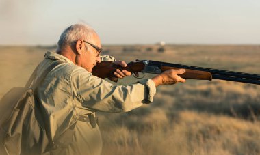 Kırsal alanda av tüfeğiyle avcılık yapmak, açık hava hobisinin tadını çıkarmak.