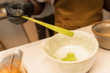 Eldiven giyip beyaz bir seramik kaseye kibrit tozu ekliyorum.