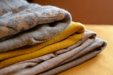 Soğuk sonbahar günleri için yeni rahat kıyafetler. Gri, bej ve sarı renkli kazaklar..